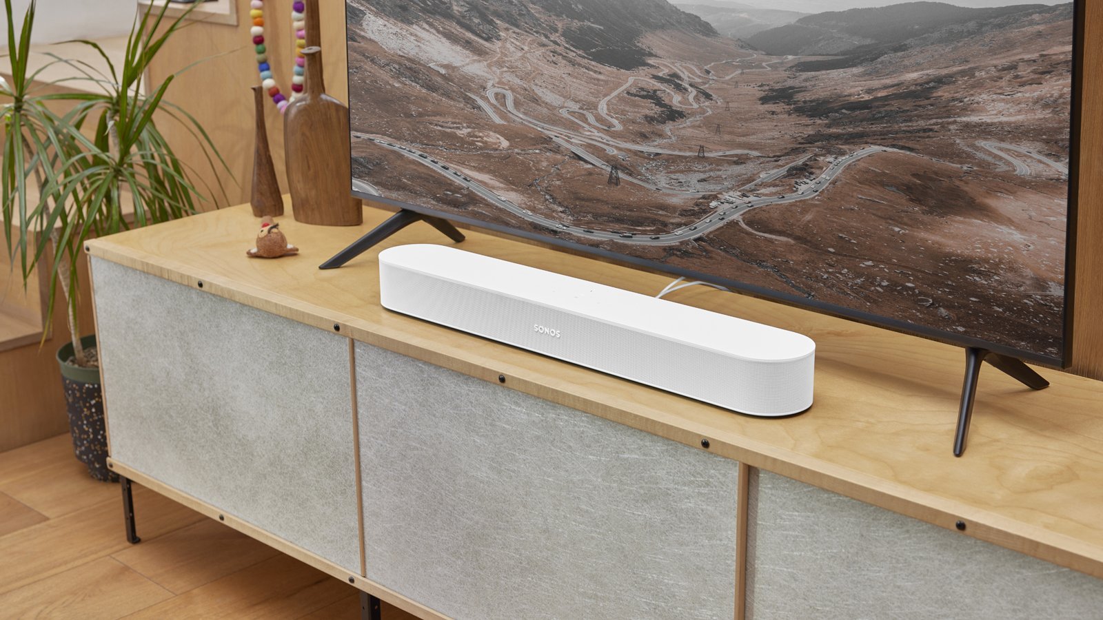 the sonos beam soundbar in white on a tv cabinet
