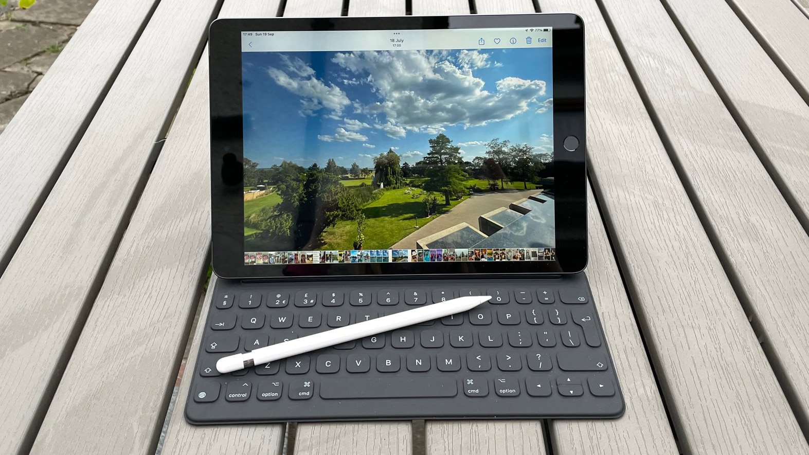 Apple iPad 10.2 (2021) avec Smart Keyboard connecté, avec un Apple Pencil posé sur le clavier, à l'extérieur