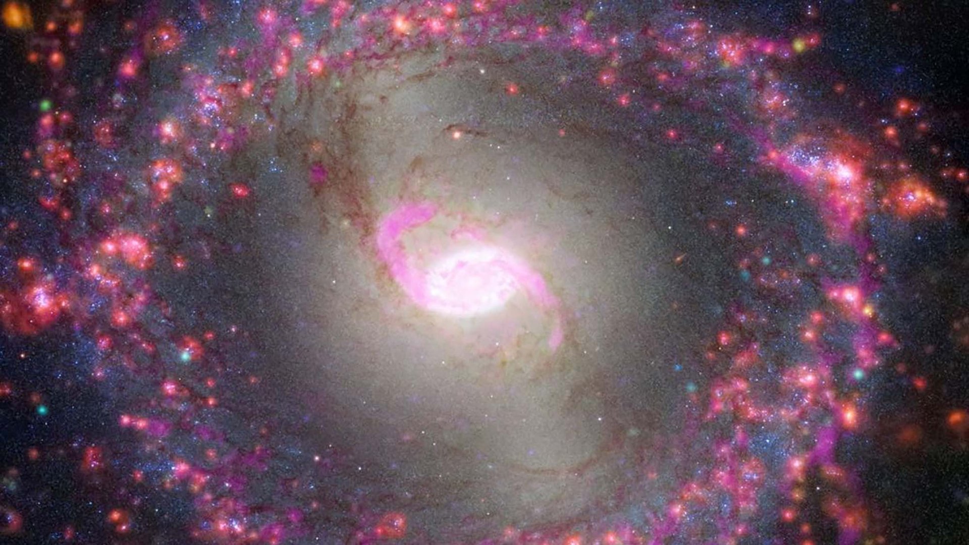 Una galassia a spirale con una struttura a barra luminosa al centro.