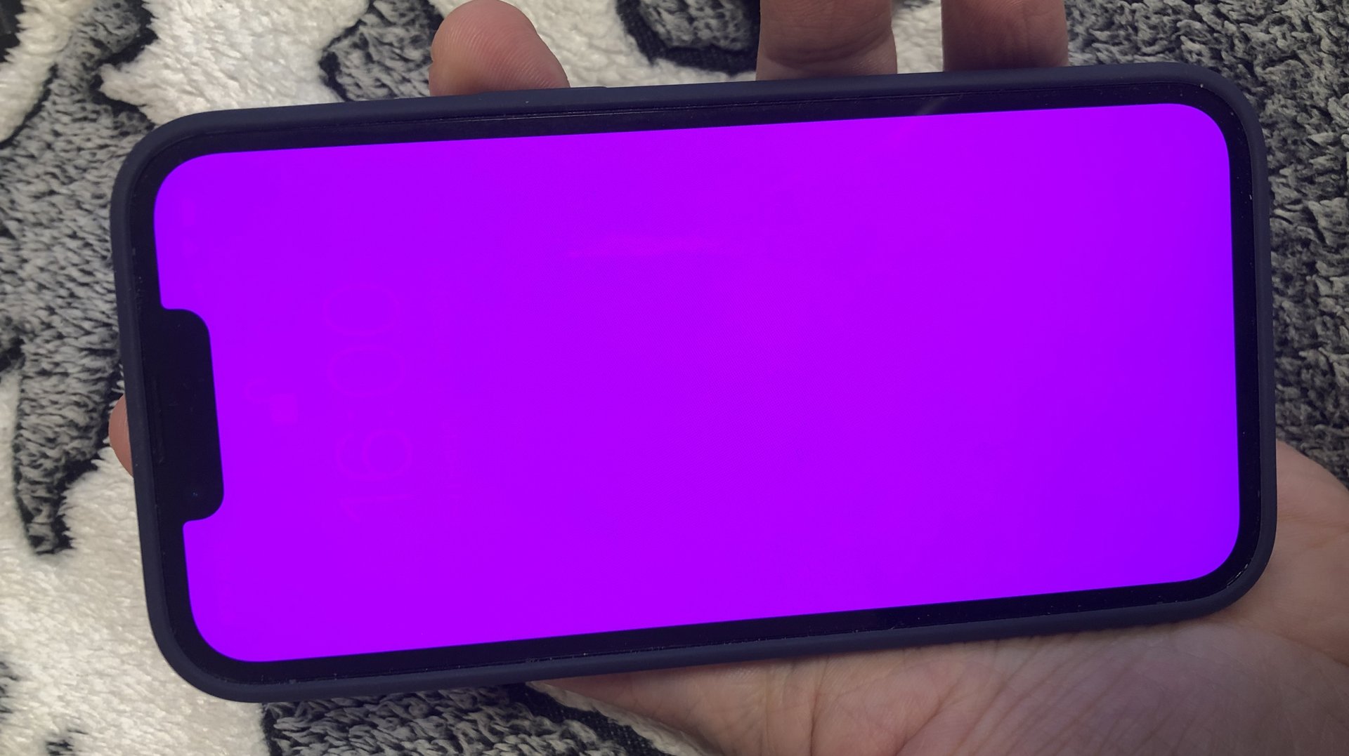 Un iPhone 13 Pro avec un écran rose