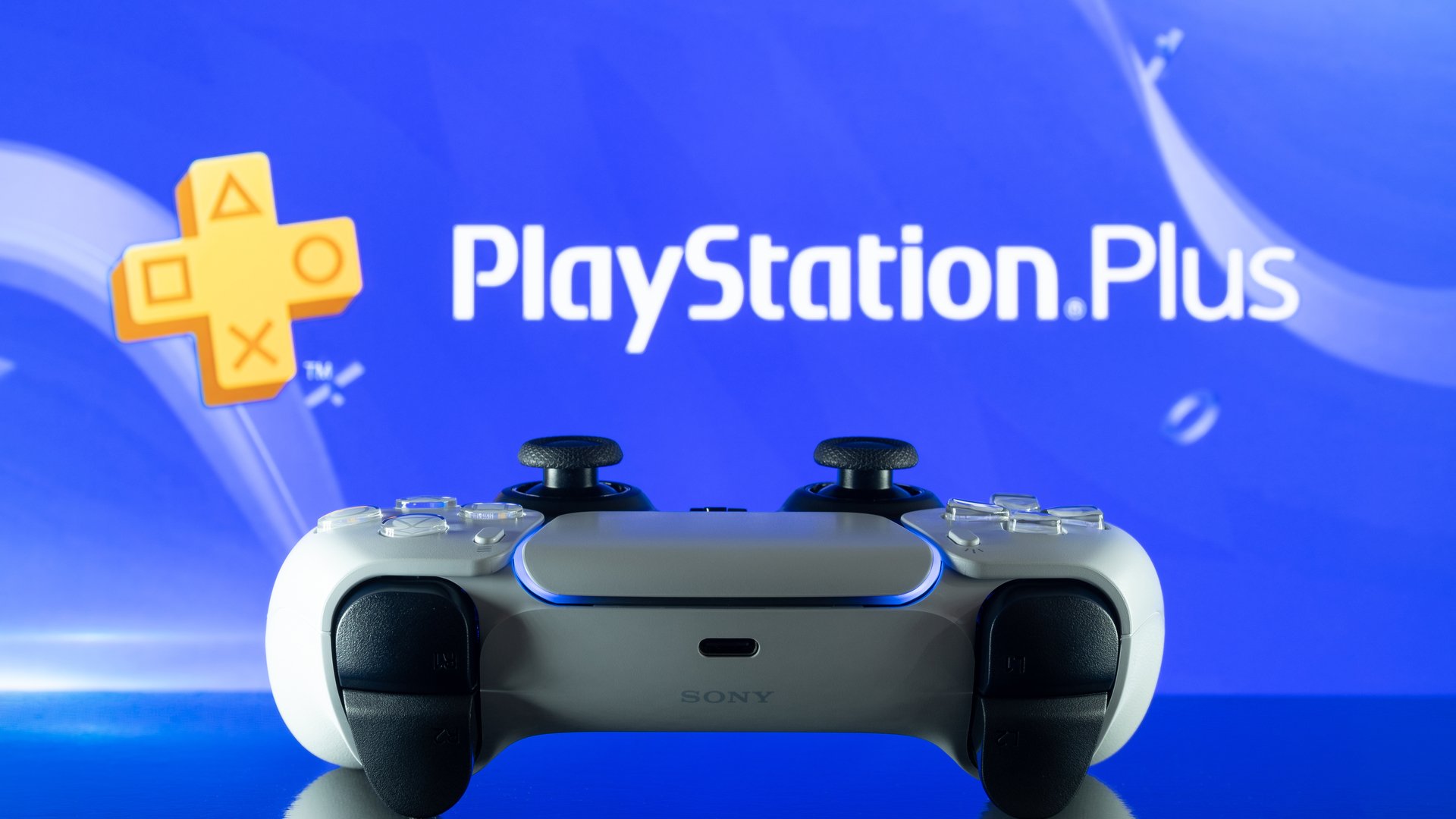 PS5 DualSense controller in front of the PlayStation Plus logo