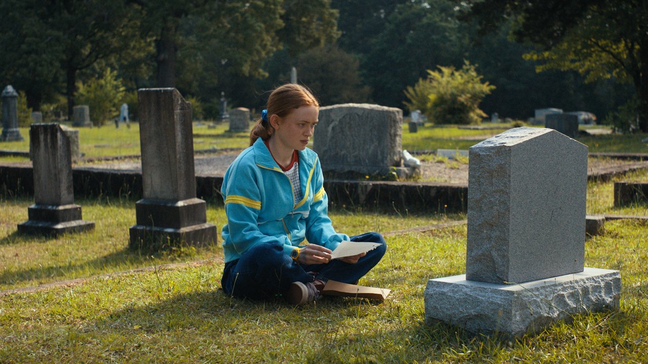 Max se sienta frente a la tumba de Billy durante el día en la temporada 4 de Stranger Things