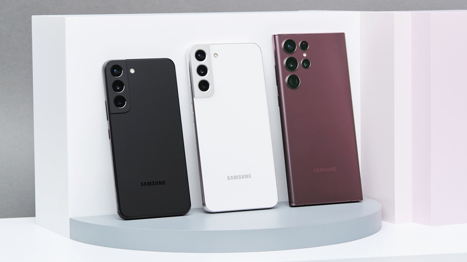 Семейство Samsung Galaxy S22, подпираемое задней частью выставленных телефонов.