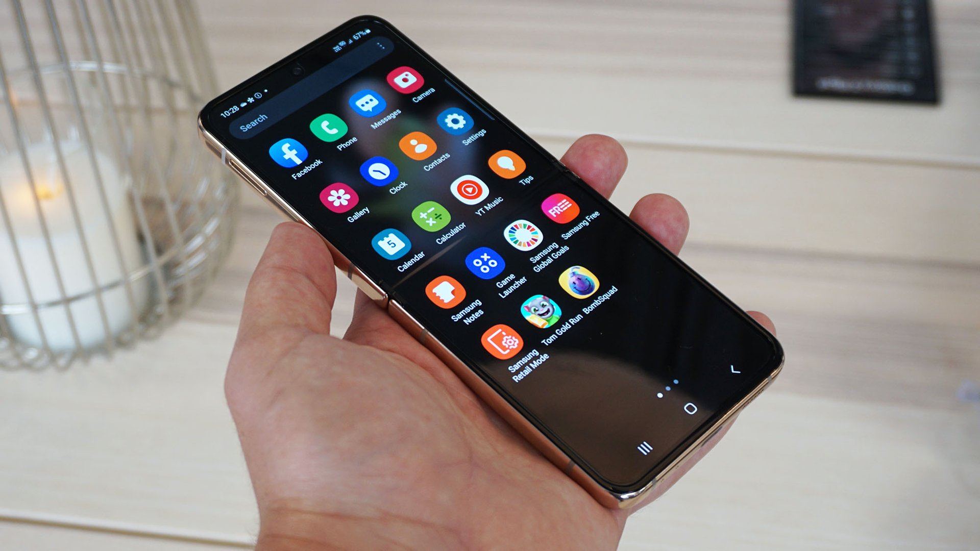 Samsung Galaxy Z Flip 4 manos en el frente beige en ángulo