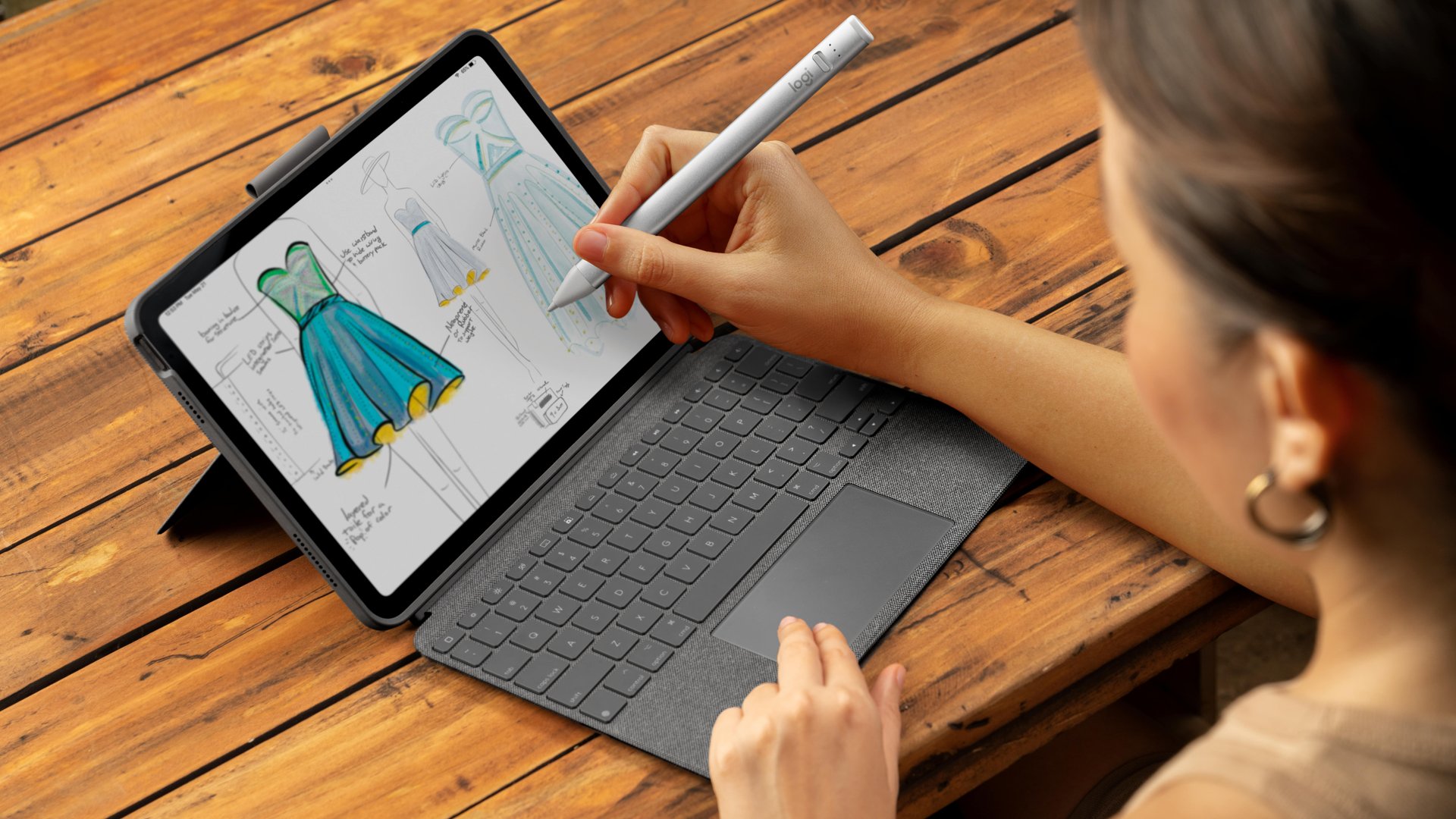 El estuche con teclado Logitech Combo Touch con trackpad y Logitech Pencil usado en un iPad por un diseñador de ropa.