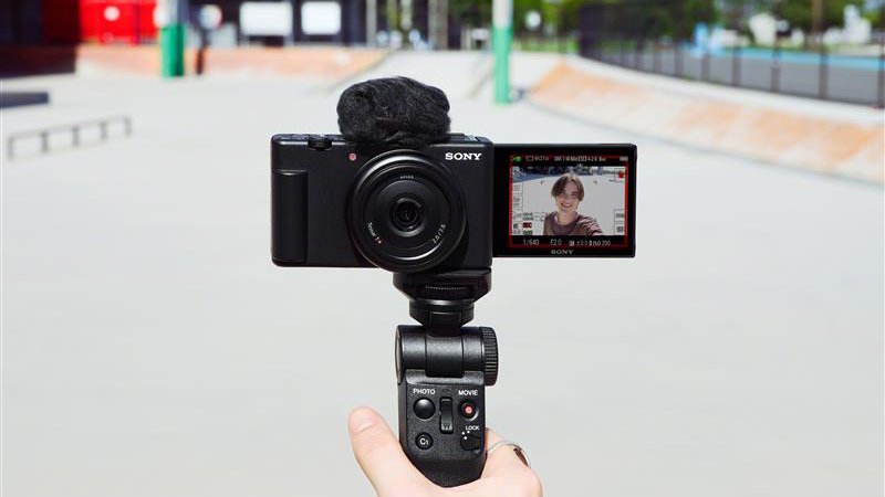 Una mano que sostiene la cámara Sony ZV1-F en un mini trípode