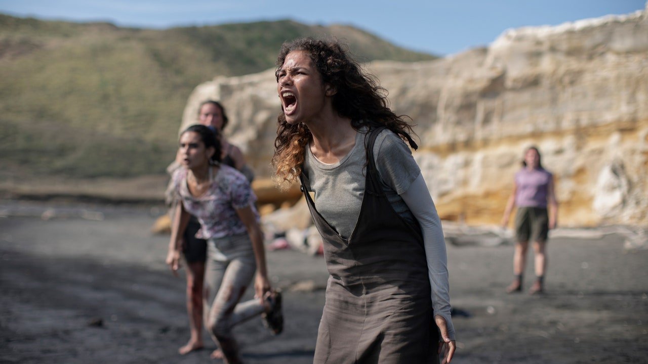 Dziewczyna woła o pomoc, stojąc na plaży w dodatkowym filmie The Wilds sezonu 1