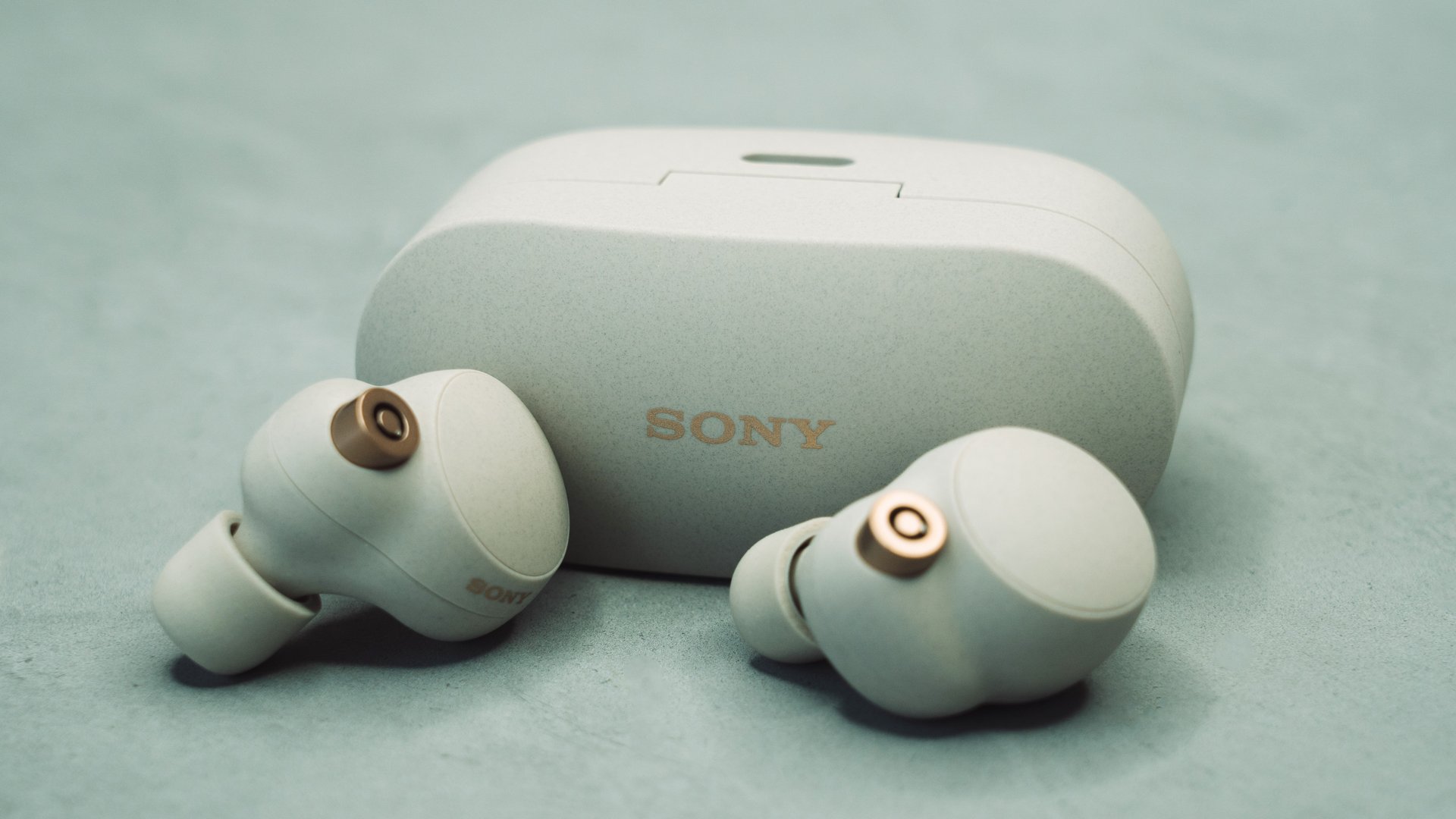 Sony WF-1000XM4 Ohrhörer auf grüner Oberfläche