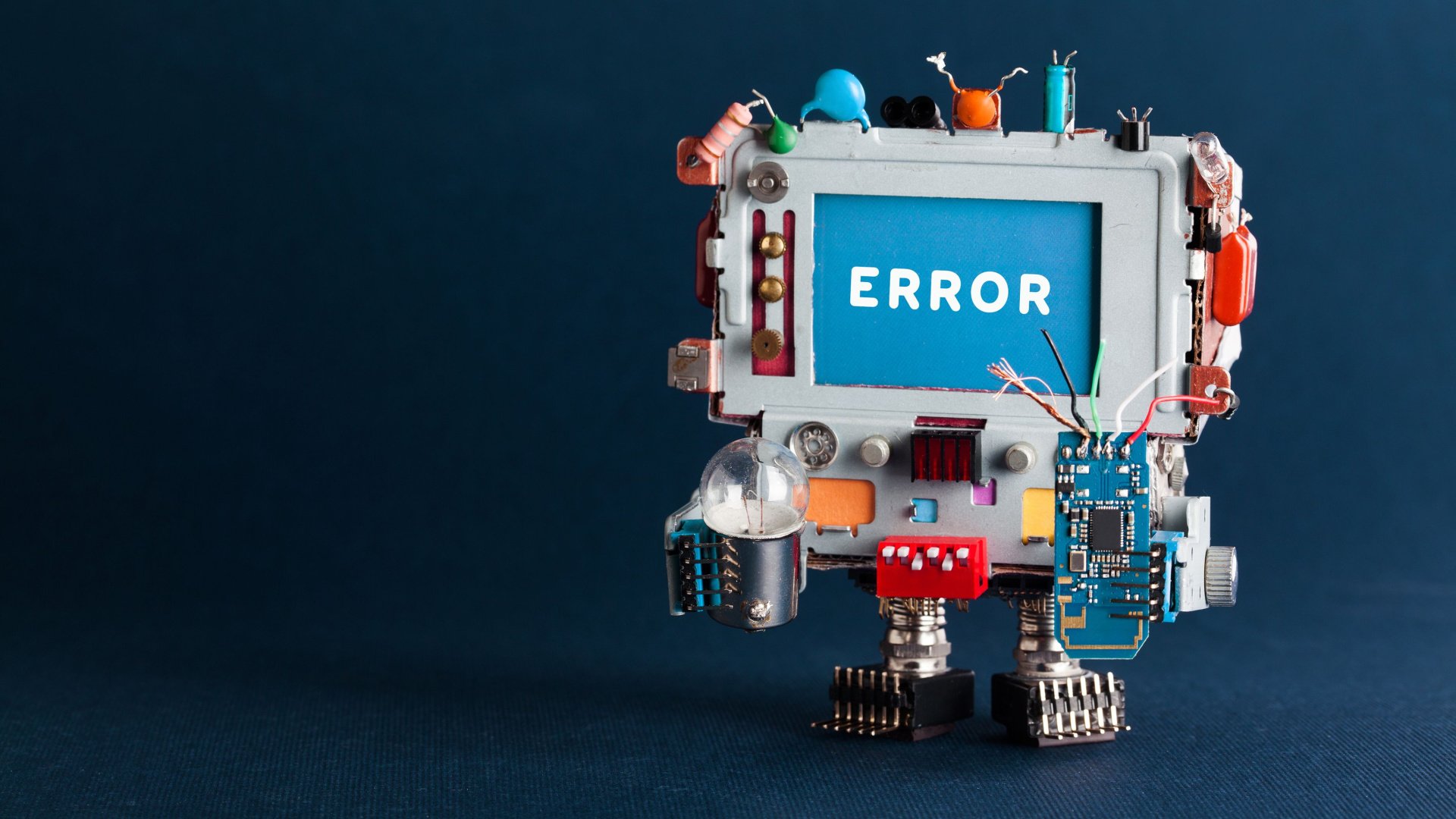 Computadora robótica de juguete con bombilla y circuito roto sobre fondo azul oscuro.  Error de mensaje de texto en pantalla azul.